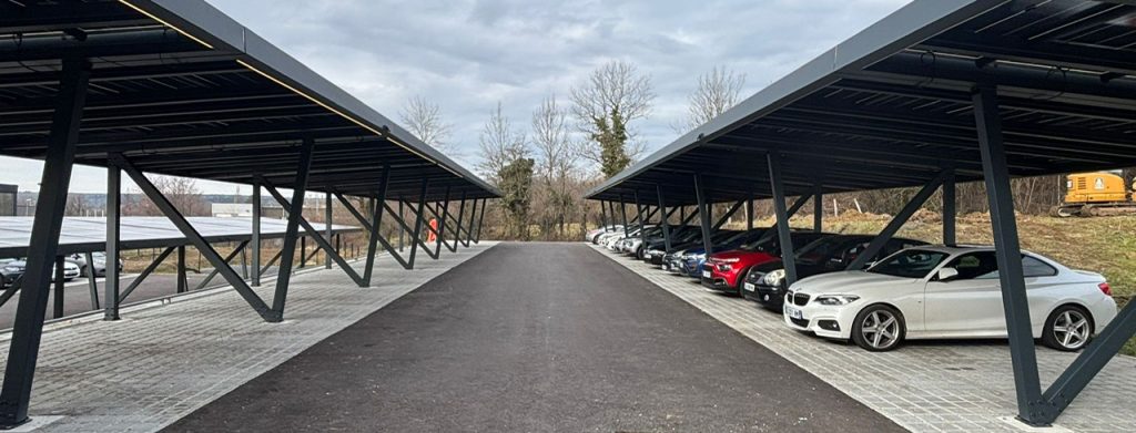 Deux rangées d'ombrières solaires Deux rangées d'ombrières solaires en aluminium anthracite couvrant les places d'un grand parking de part et d'autre d'une allée