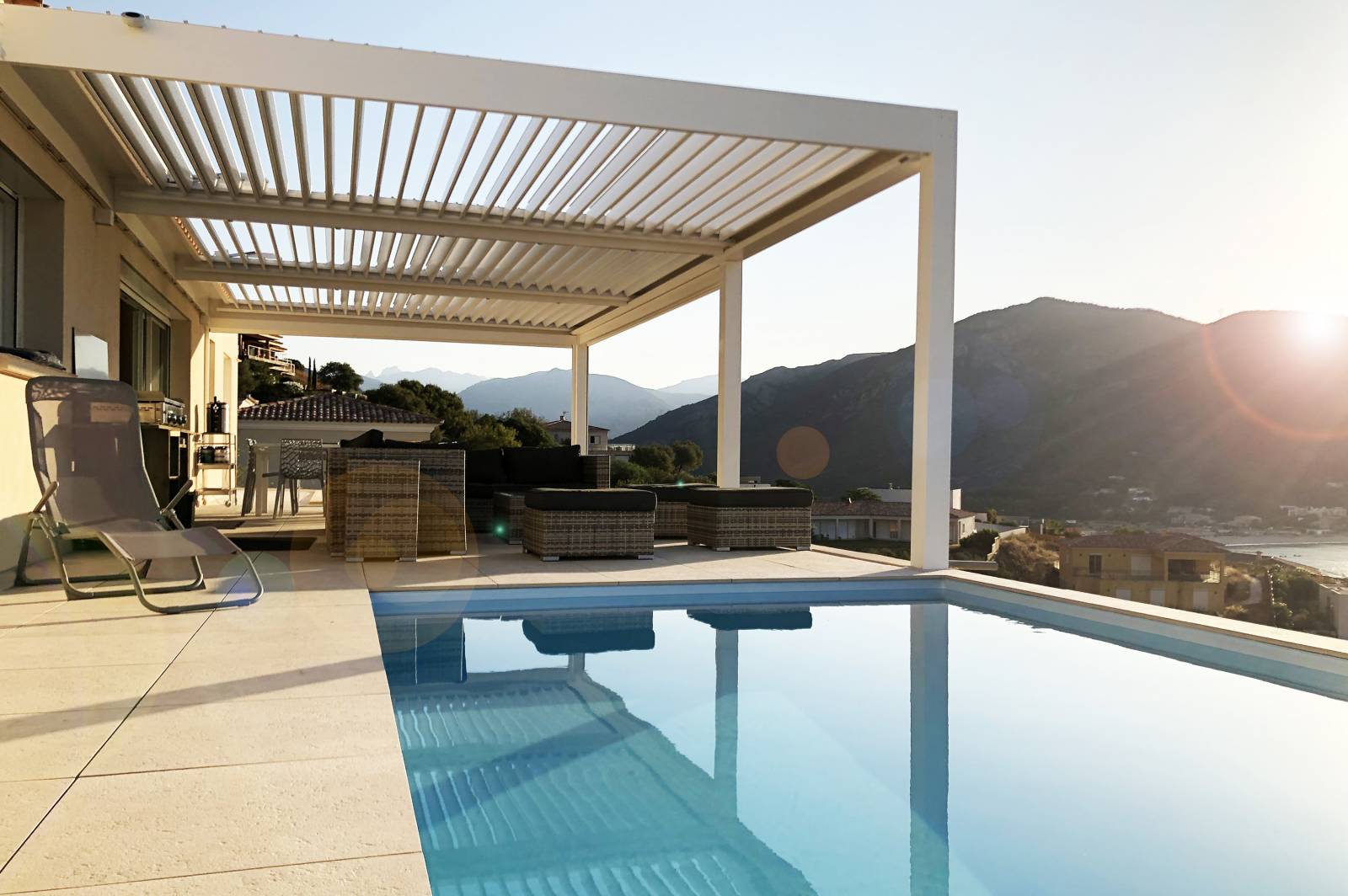 Pergola bioclimatique à lames orientables sur une terrasse avec piscine