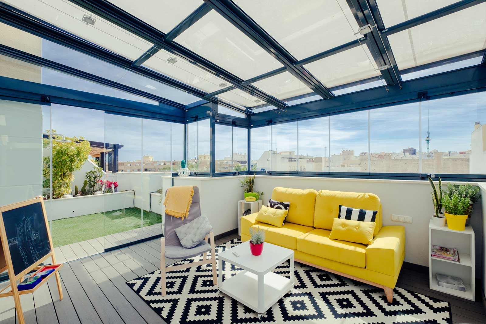 Pergola vitrée à toit coulissant sur un toit-terrasse, aménagée en salon